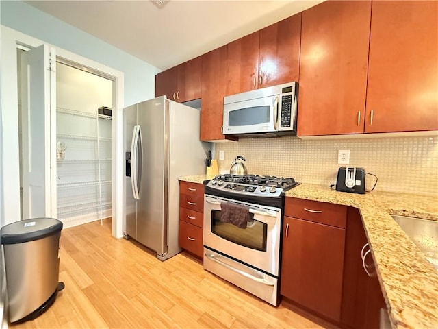 3655 Peachtree Rd NE Unit 304, Atlanta, GA 30319 - kitchen with stainless steel appliances, light wood-style flooring, decorative backsplash, and light stone countertops