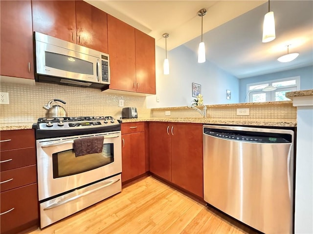 3655 Peachtree Rd NE Unit 304, Atlanta, GA 30319 - kitchen featuring appliances with stainless steel finishes, light wood finished floors, backsplash, a peninsula, and decorative light fixtures