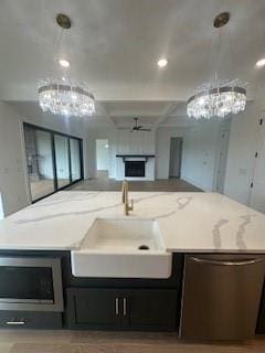 kitchen with a fireplace, open floor plan, stainless steel appliances, and decorative light fixtures