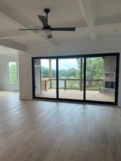 empty room featuring a ceiling fan, coffered ceiling, beamed ceiling, and wood finished floors