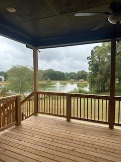 wooden terrace featuring a water view and a ceiling fan