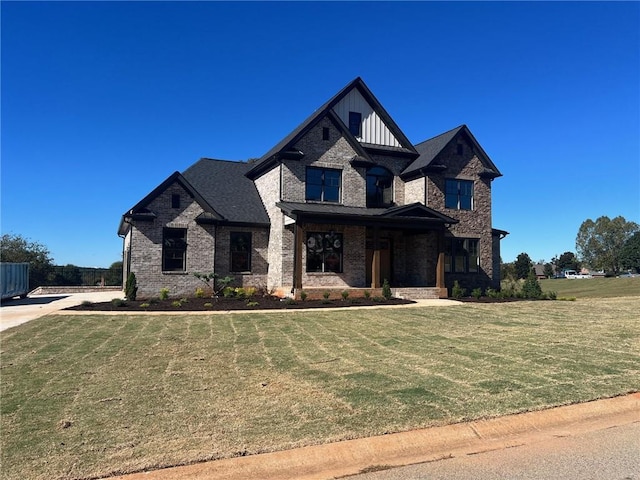 view of front facade featuring board and batten siding, brick siding, and a front lawn