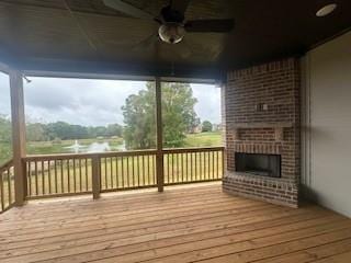 wooden deck with ceiling fan and a fireplace