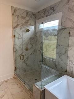 full bathroom with marble finish floor, a freestanding tub, and a shower stall