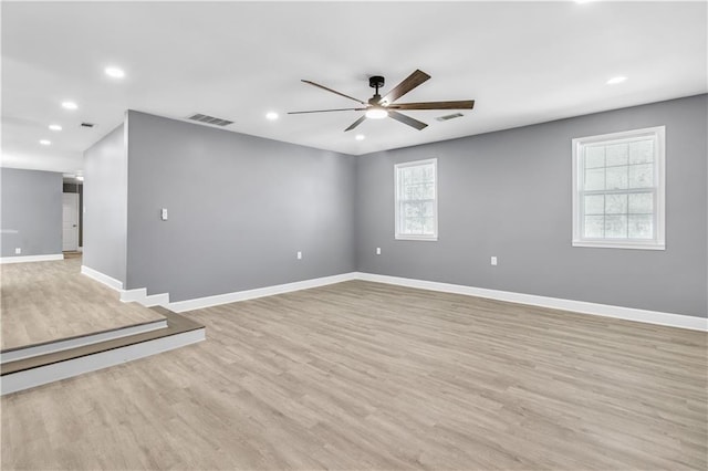 unfurnished room with recessed lighting, visible vents, a ceiling fan, light wood-type flooring, and baseboards