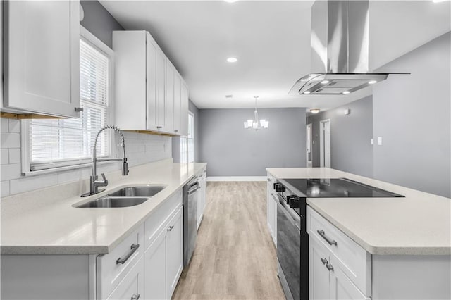 kitchen featuring a kitchen island, appliances with stainless steel finishes, range hood, light wood-style floors, and a sink