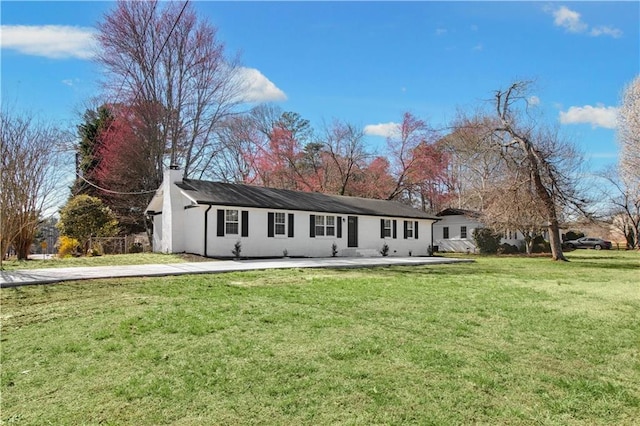 view of front facade with a front yard and a chimney