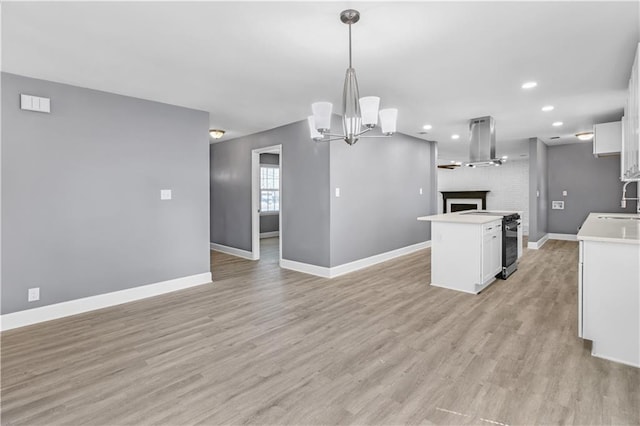 kitchen with light wood-type flooring, open floor plan, white cabinetry, and island exhaust hood