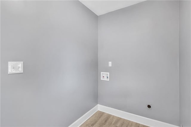 clothes washing area with hookup for a washing machine, light wood-style floors, hookup for an electric dryer, laundry area, and baseboards