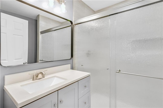 full bathroom with a shower with shower door and vanity