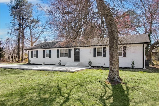 back of property with entry steps, crawl space, brick siding, and a lawn