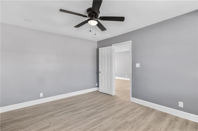 empty room featuring light wood-style flooring, baseboards, and a ceiling fan