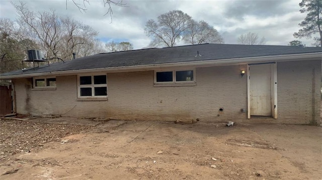 back of house featuring brick siding and cooling unit