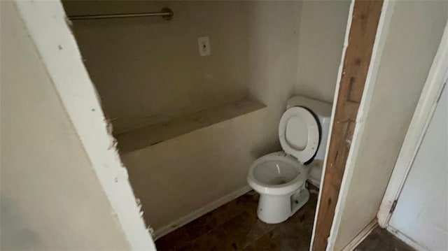 bathroom featuring baseboards and toilet