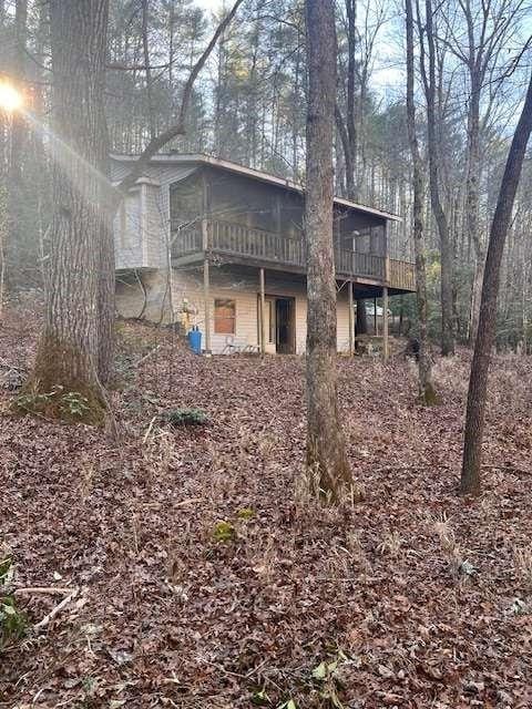 back of house with a sunroom and a wooden deck