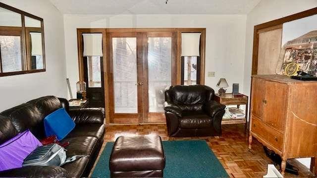 living area featuring dark parquet flooring, french doors, and vaulted ceiling