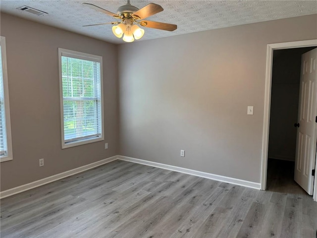 7454 Woody Springs Dr, Flowery Branch, GA 30542 - empty room with light wood-style flooring, ceiling fan, a textured ceiling, and baseboards