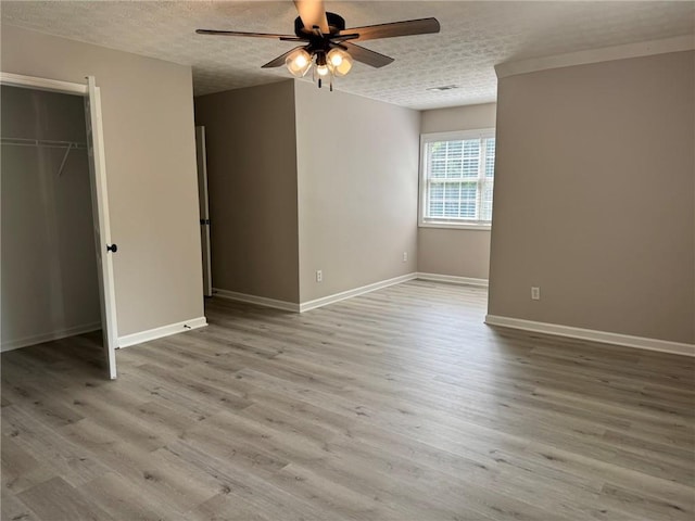 7454 Woody Springs Dr, Flowery Branch, GA 30542 - unfurnished bedroom with baseboards, wood finished floors, a textured ceiling, ceiling fan, and a closet