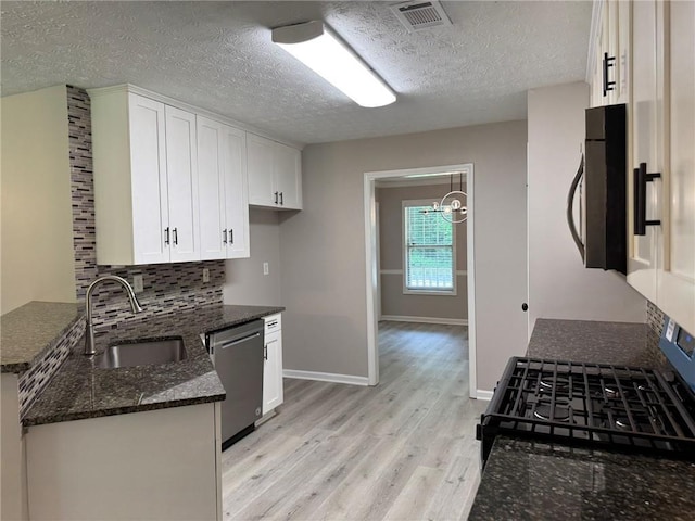7454 Woody Springs Dr, Flowery Branch, GA 30542 - kitchen featuring a sink, appliances with stainless steel finishes, light wood finished floors, dark stone counters, and white cabinets