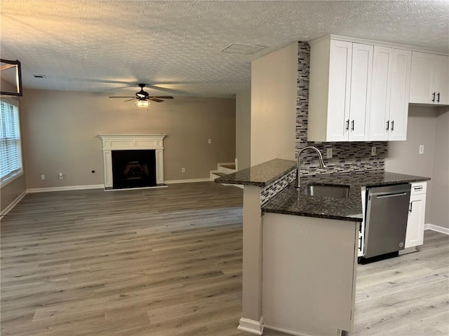 7454 Woody Springs Dr, Flowery Branch, GA 30542 - kitchen with a sink, stainless steel dishwasher, a ceiling fan, light wood-style floors, and a textured ceiling