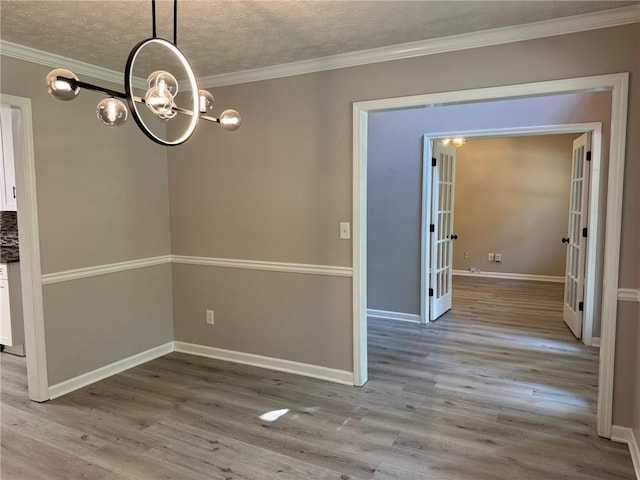 7454 Woody Springs Dr, Flowery Branch, GA 30542 - unfurnished dining area featuring a chandelier, wood finished floors, ornamental molding, baseboards, and a textured ceiling