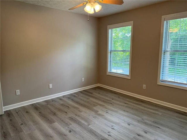 7454 Woody Springs Dr, Flowery Branch, GA 30542 - unfurnished room with healthy amount of natural light, ceiling fan, wood finished floors, and baseboards
