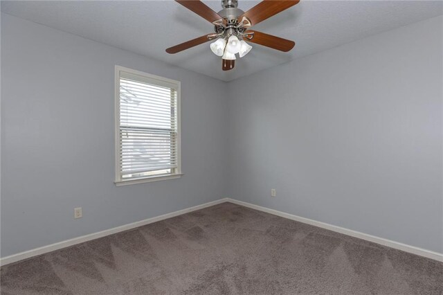 carpeted spare room with a ceiling fan and baseboards