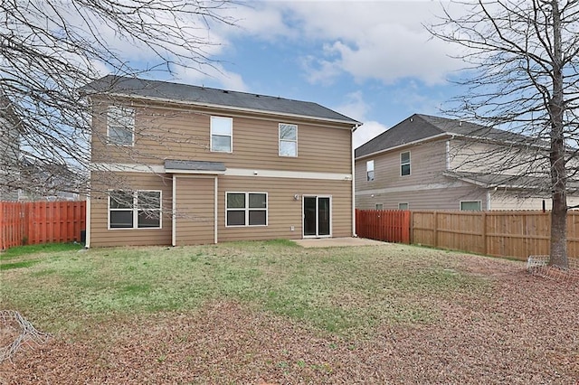 rear view of property featuring a patio area, a yard, and a fenced backyard