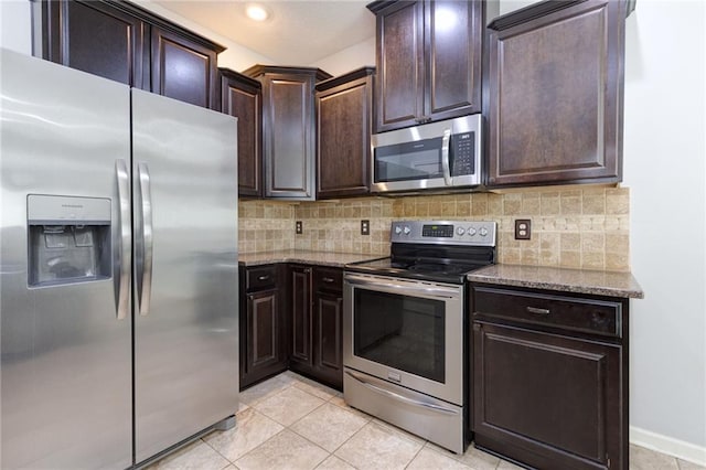 kitchen featuring stainless steel appliances, light stone countertops, dark brown cabinetry, and decorative backsplash