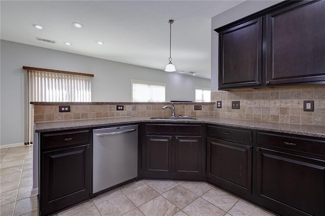 kitchen featuring tasteful backsplash, visible vents, dishwasher, stone counters, and a sink