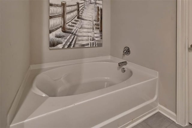 bathroom featuring baseboards, a garden tub, and tile patterned floors