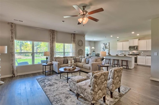 living area featuring dark wood-style floors, baseboards, visible vents, and recessed lighting