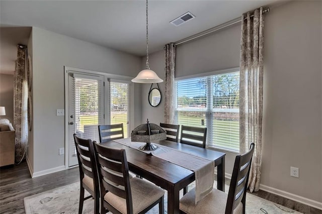 dining space featuring visible vents, baseboards, and wood finished floors