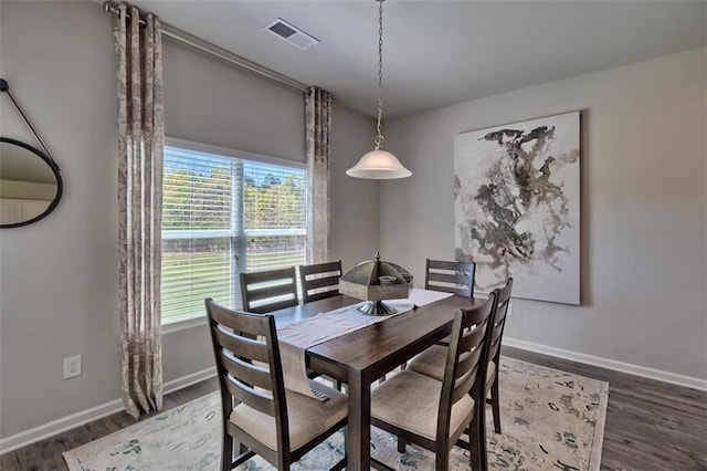 dining space featuring baseboards, visible vents, and wood finished floors