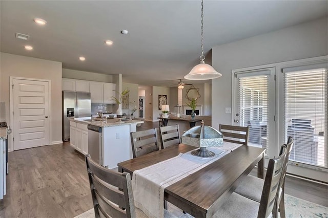 dining room featuring a wealth of natural light, visible vents, and wood finished floors