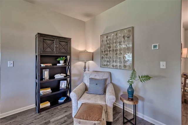 living area featuring baseboards and wood finished floors