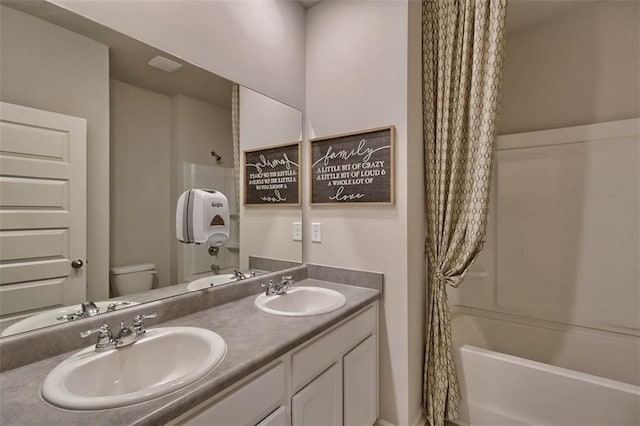 full bathroom featuring a sink, toilet, and double vanity