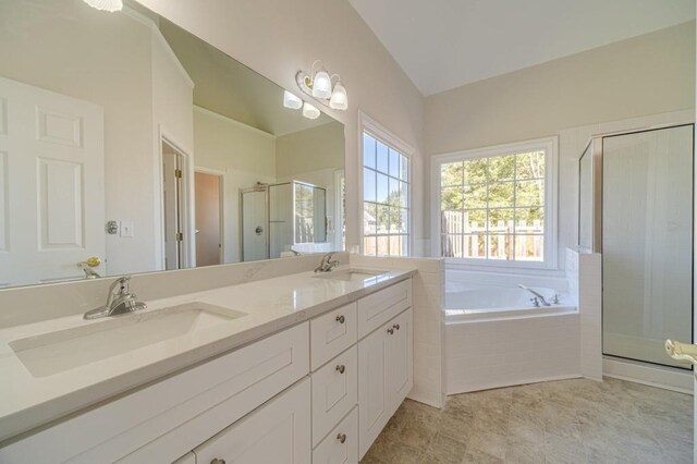 bathroom with vanity, separate shower and tub, and vaulted ceiling