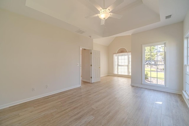 spare room featuring a tray ceiling, light hardwood / wood-style floors, and ceiling fan