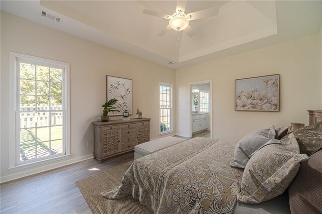 bedroom featuring ceiling fan, a tray ceiling, and hardwood / wood-style floors