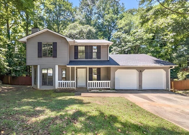 view of front facade with a garage, a porch, and a front lawn