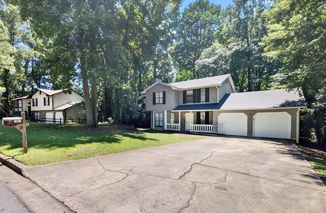 view of front facade featuring a garage, a front yard, and covered porch