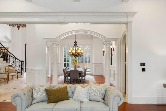 living room with hardwood / wood-style floors, a notable chandelier, and crown molding