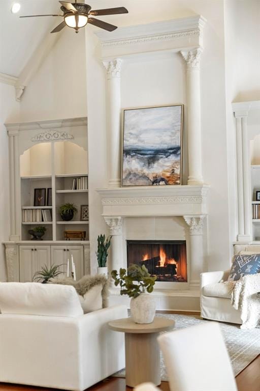 living room featuring high vaulted ceiling, ceiling fan, built in shelves, beam ceiling, and wood-type flooring