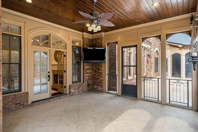 unfurnished sunroom featuring ceiling fan and wooden ceiling