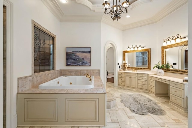 bathroom featuring a notable chandelier, vanity, a bathtub, and ornamental molding