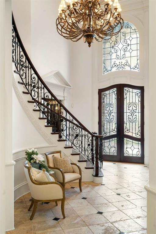 entrance foyer featuring a wealth of natural light, french doors, a towering ceiling, and a chandelier