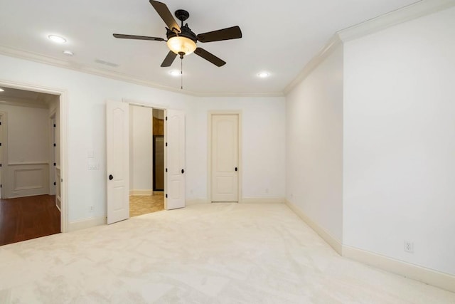 unfurnished bedroom with light colored carpet, ceiling fan, and ornamental molding