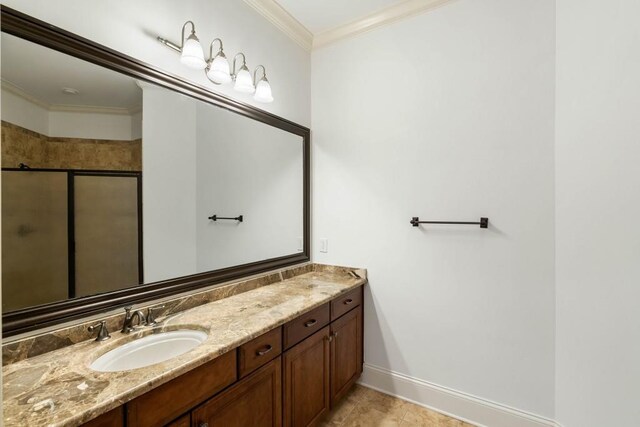 bathroom with tile patterned floors, crown molding, vanity, and a shower with shower door