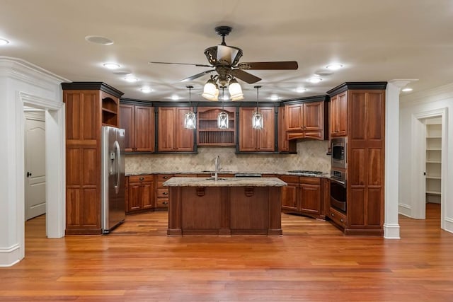 kitchen featuring tasteful backsplash, stainless steel appliances, ceiling fan, hardwood / wood-style flooring, and hanging light fixtures